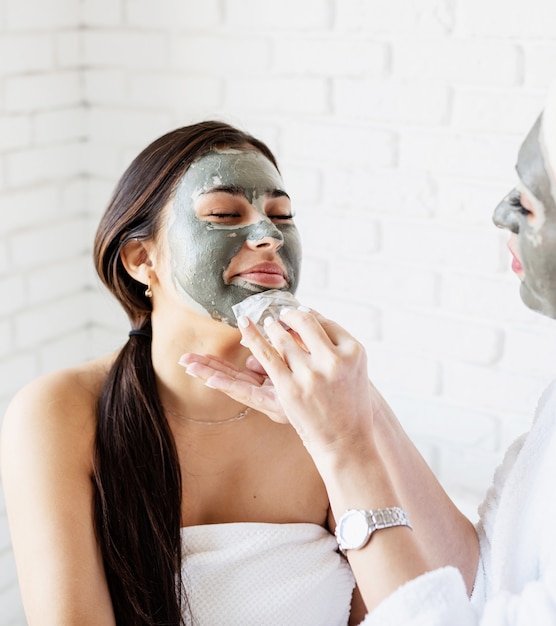 Photo spa and wellness concept. self care. portrait of a beautiful woman applying facial mask doing spa procedures