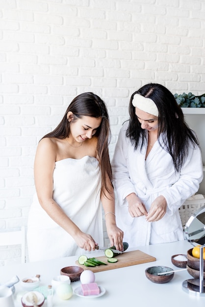 Spa and wellness concept. Self care. two beautiful women doing spa procedures cutting cucumbers