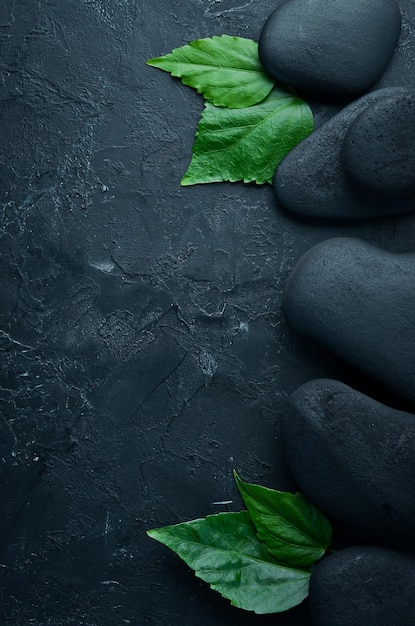 スパウェルネスリラックスコンセプトマッサージとスパ用の黒い石とアクセサリー上面図テキスト用の空きスペース