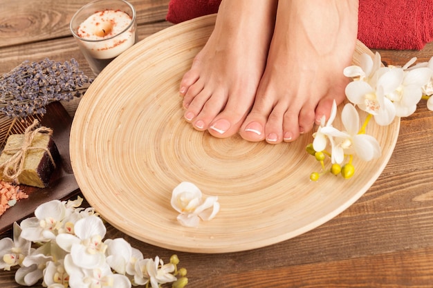 Photo spa and wellness setting with female feet on a plate