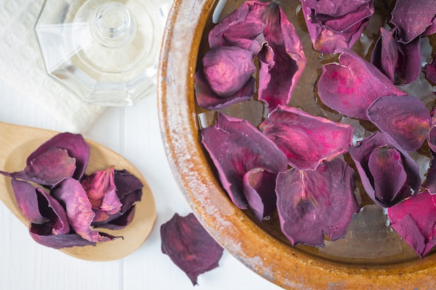 Spa  with beautiful rose petals and a clay bowl.