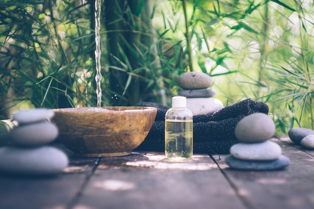 Spa with woman hands and clear water on an old wood