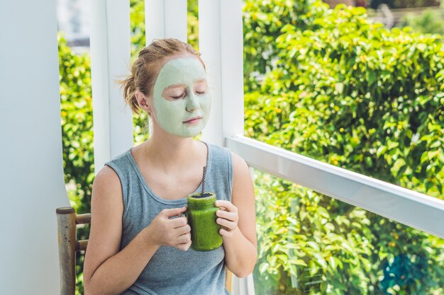 Donna della stazione termale che applica maschera facciale all'argilla verde