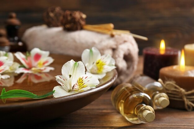 Spa wooden bowl with water and flowers closeup