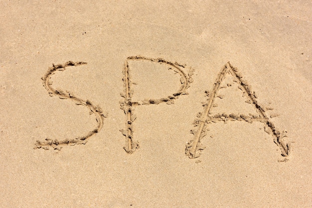 Spa scritta sulla spiaggia di sabbia