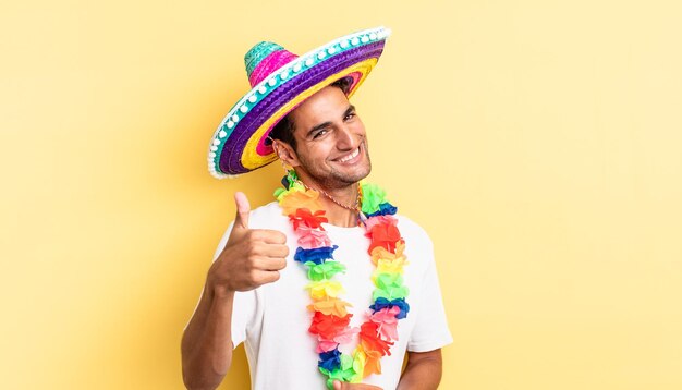 Spaanse knappe man voelt zich trots, positief glimlachend met duimen omhoog. Mexicaans feestconcept