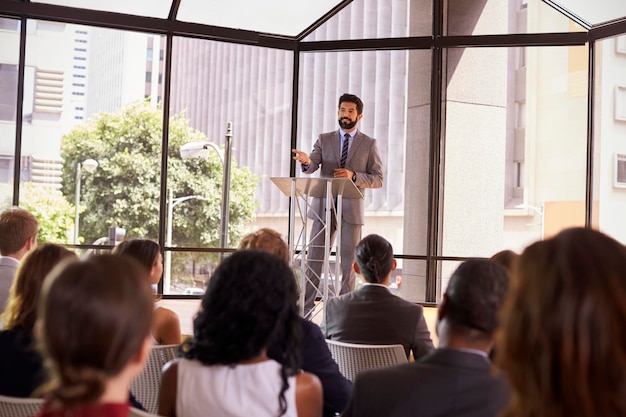 Spaanse man die bedrijfsseminar presenteert aan publiek