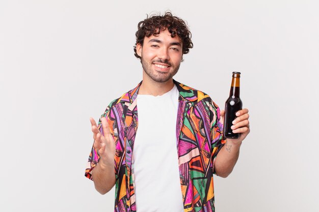 Spaanse man met bier die zich blij, verrast en opgewekt voelt, glimlacht met een positieve houding, een oplossing of idee realiseert