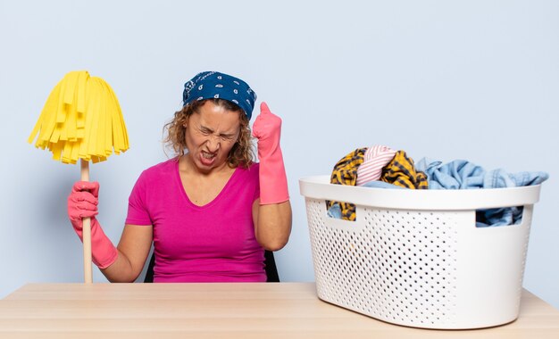 Foto spaanse middelbare leeftijd vrouw op zoek ongelukkig en gestrest, zelfmoordgebaar pistool ondertekenen met hand, wijzend naar het hoofd