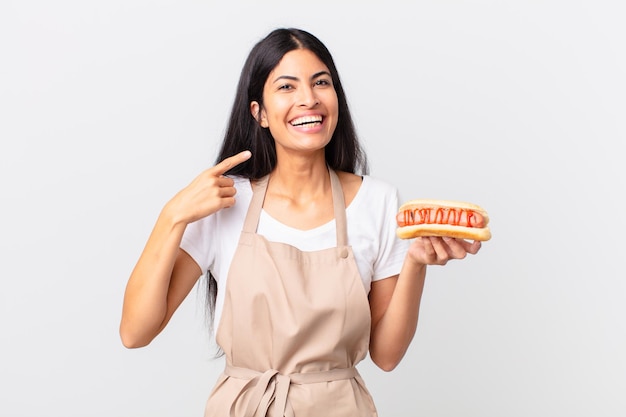 Spaanse mooie chef-kokvrouw die een hotdog houdt