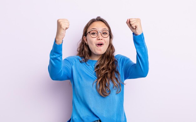 Spaanse mooie vrouw die een ongelooflijk succes viert als een winnaar, er opgewonden en blij uitziet en zegt: neem dat maar!