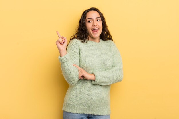 Spaanse mooie vrouw die gelukkig glimlacht en zijwaarts kijkt, zich afvragend of ze denkt of een idee heeft