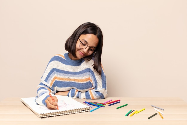 Spaanse mooie vrouw die op een schetsboek trekt