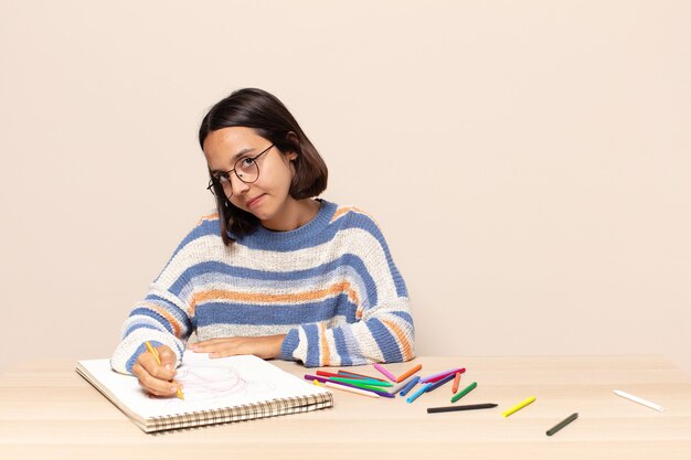 Spaanse mooie vrouw die op een schetsboek trekt