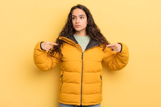 Foto spaanse mooie vrouw die trots positief en casual kijkt en met beide handen naar de borst wijst