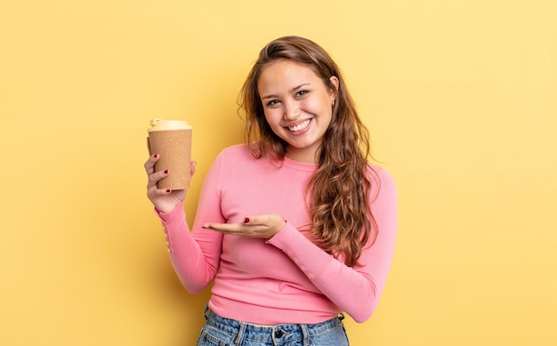 Spaanse mooie vrouw die vrolijk glimlacht, zich gelukkig voelt en een concept toont. afhaal koffie concept