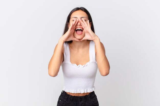 Spaanse mooie vrouw die zich gelukkig voelt, een grote schreeuw geeft met de handen naast de mond