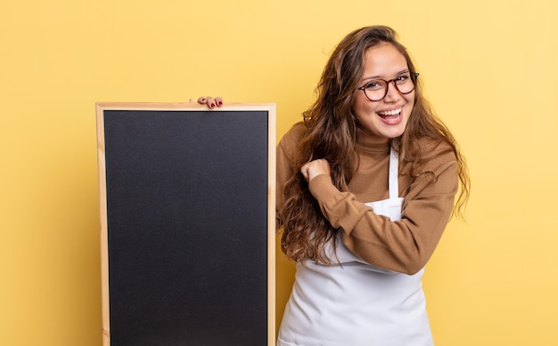 Spaanse mooie vrouw die zich gelukkig voelt en een uitdaging aangaat of viert. schoolbord kopie ruimte concept