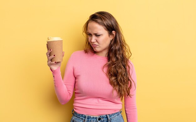 Foto spaanse mooie vrouw die zich verdrietig, overstuur of boos voelt en opzij kijkt. afhaal koffie concept