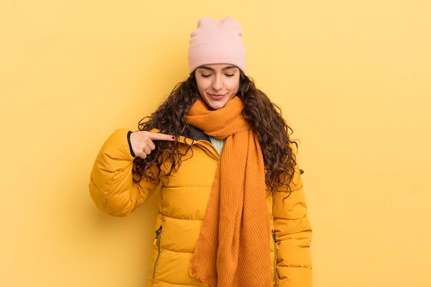 Spaanse mooie vrouw glimlachend vrolijk en nonchalant naar beneden kijkend en wijzend naar de borst