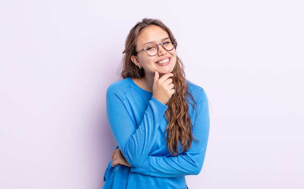 Spaanse mooie vrouw lacht, geniet van het leven, voelt zich gelukkig, vriendelijk, tevreden en zorgeloos met de hand op de kin