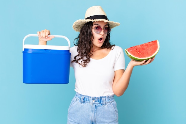 Spaanse mooie vrouw met een draagbare koelkast en een watermeloen