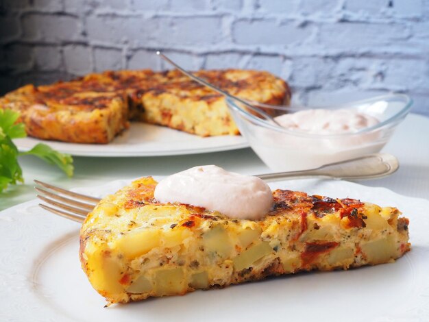 Spaanse omelet met aardappelen en zongedroogde tomatensaus en onweerstaanbare plakjes in focus