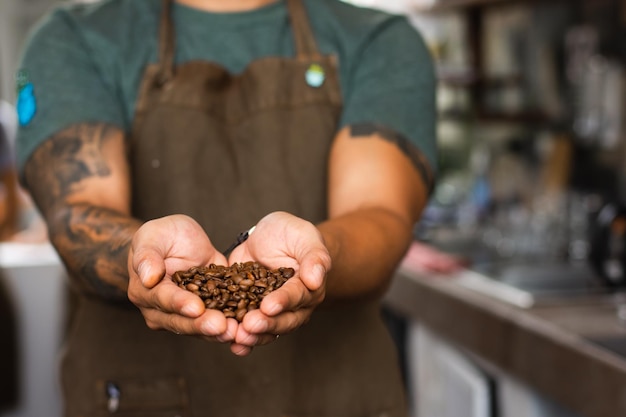 Spaanse onherkenbare man met koffiebonen in zijn handen