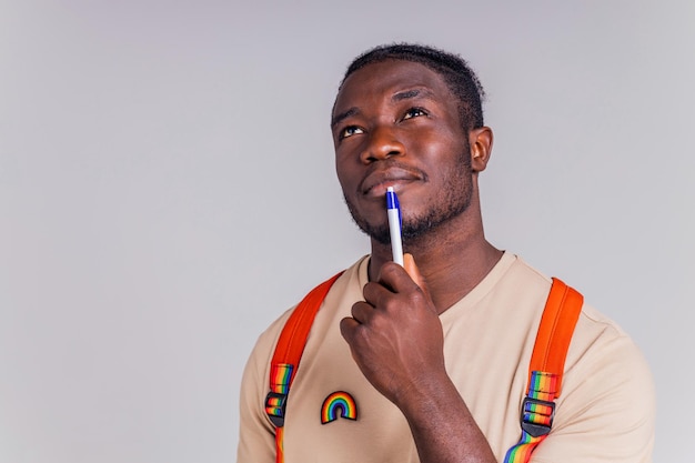 Spaanse student man met regenboog badge op tshirt in studio isolate