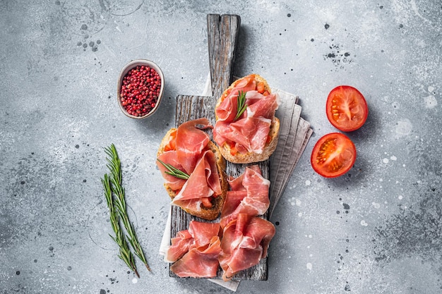 Spaanse Tapas Toast Met Tomaten En Gezouten Plakjes Jamon Iberico Ham Op Houten Bord Grijze Achtergrond Bovenaanzicht