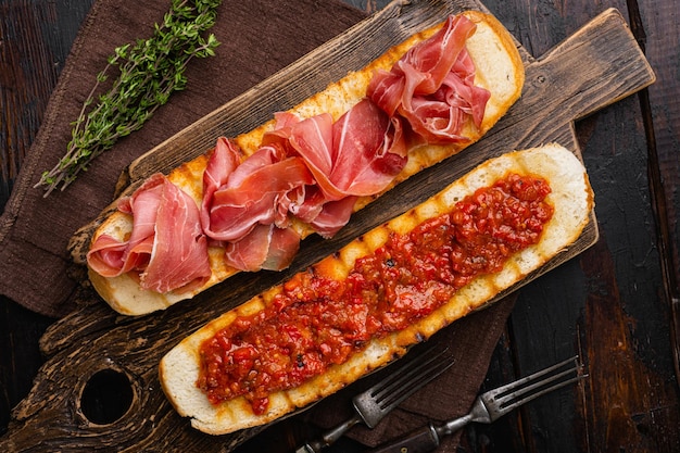 Spaanse tomaat en jamon toast op oude donkere houten tafel achtergrond bovenaanzicht plat lag