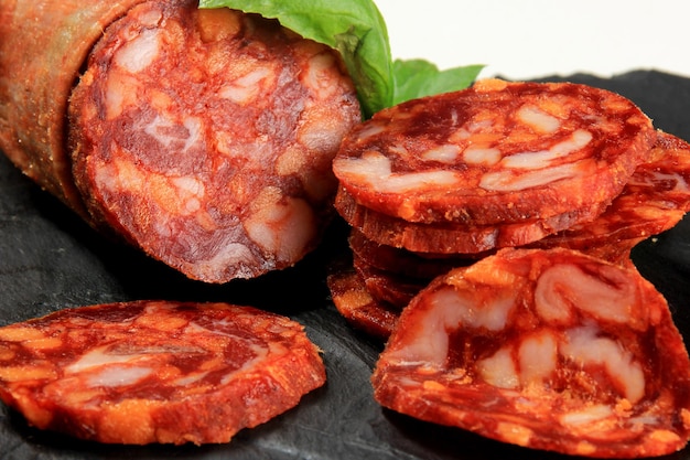 Spaanse varkensvlees chorizo salami worst segment op zwarte stenen plaat. chorizo iberische extra worstplak