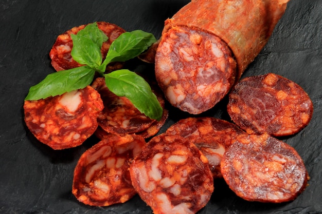 Spaanse varkensvlees chorizo salami worst segment op zwarte stenen plaat. Chorizo Iberische extra worstplak