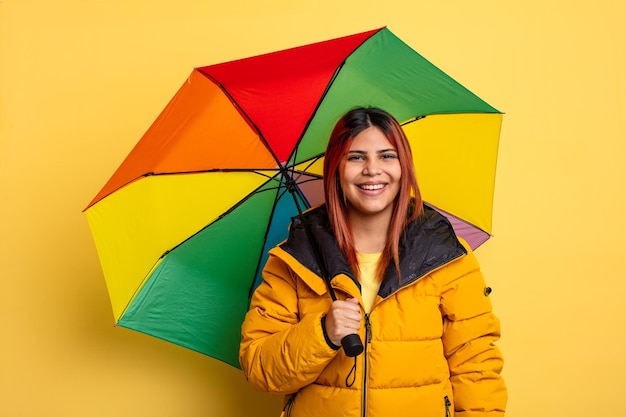 Spaanse vrouw die gelukkig en aangenaam verrast kijkt. regen en paraplu concept