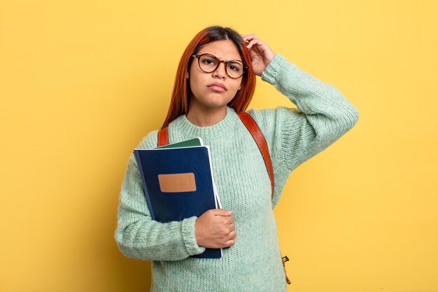 Spaanse vrouw die gelukkig glimlacht en dagdroomt of twijfelt. studentenconcept