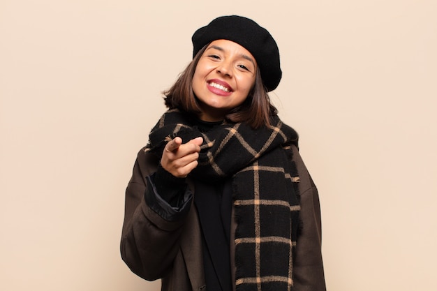 Spaanse vrouw die met een tevreden, zelfverzekerde, vriendelijke glimlach wijst en jou kiest