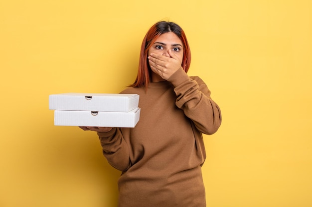 Spaanse vrouw die mond bedekt met handen met een geschokt. afhaal pizza's concept