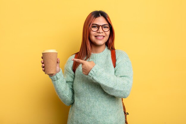 Spaanse vrouw die vrolijk lacht, zich gelukkig voelt en naar de zijkant wijst. student met een koffieconcept