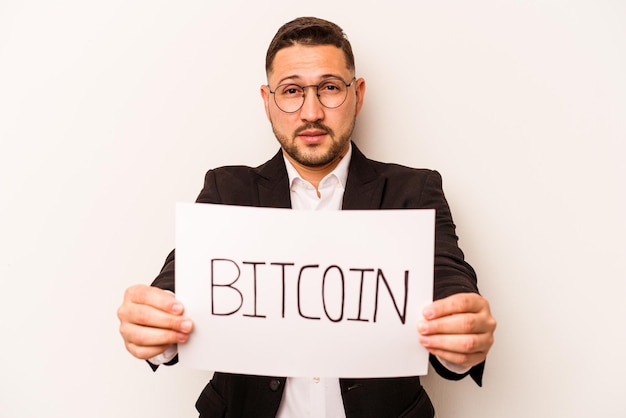 Spaanse zakenman met een bitcoin plakkaat geïsoleerd op een witte achtergrond