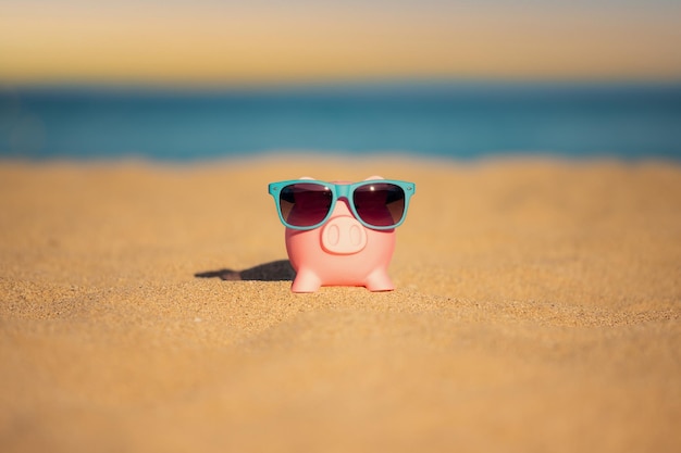 Spaarpot op het strand tegen de achtergrond van de zee en de lucht Besparingen voor zomerreizen en vakantieconcept