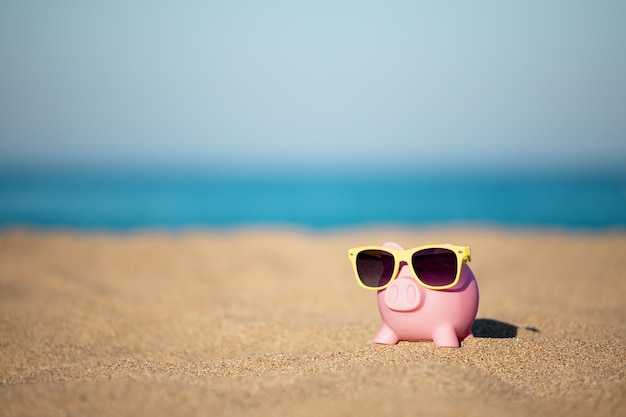 Spaarpot op het strand tegen de achtergrond van de zee en de lucht Besparingen voor zomerreizen en vakantieconcept