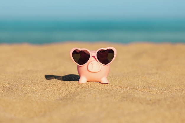 Spaarpot op het strand tegen de achtergrond van de zee en de lucht Besparingen voor zomerreizen en vakantieconcept