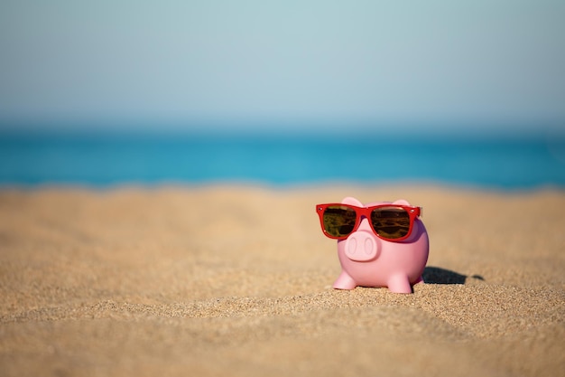 Spaarpot op het strand tegen de achtergrond van de zee en de lucht besparingen voor zomerreizen en vakantieconcept