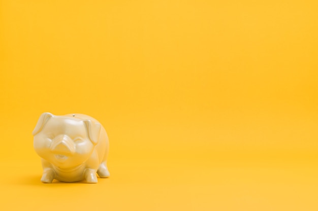 Spaarvarken geld besparen tegen gele achtergrond