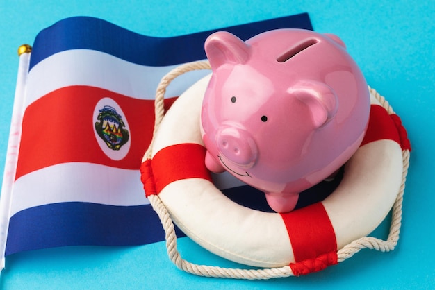 Spaarvarkenreddingsboei en vlagconcept rond het thema het redden van de economie van Costa Rica