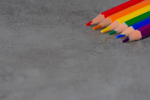 Photo space available to write with pencils with the colors of the lgbt movement on a gray background