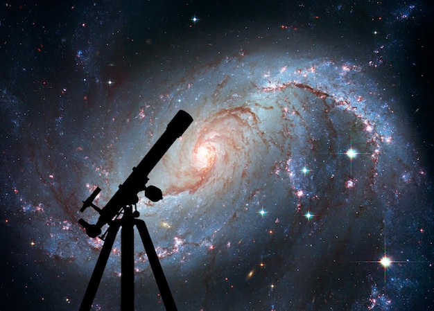 写真 望遠鏡のシルエットと空間の背景。ステラナーサリーngc1672。かじき座の渦巻銀河この画像の要素はnasaから提供されたものです。