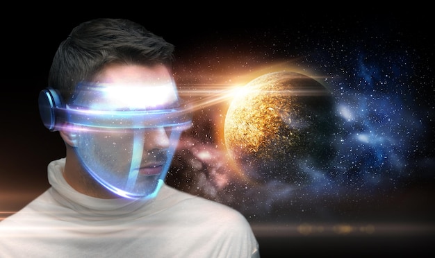 Photo space future technology and virtual reality concept man in futuristic 3d glasses over planet and stars background