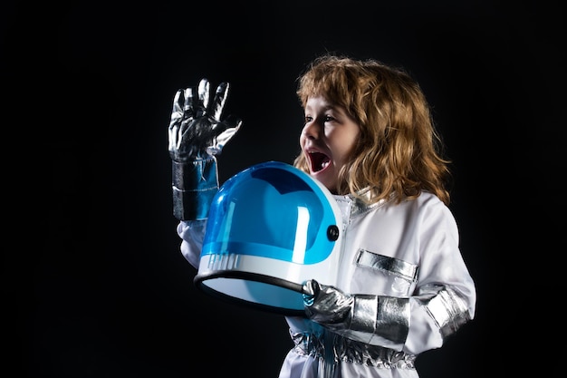 Space kids cosmonaut concept Portrait of positive little boy wearing helmet with joy Isolated background with copy space Child in an astronaut costume plays and dreams of becoming a spaceman