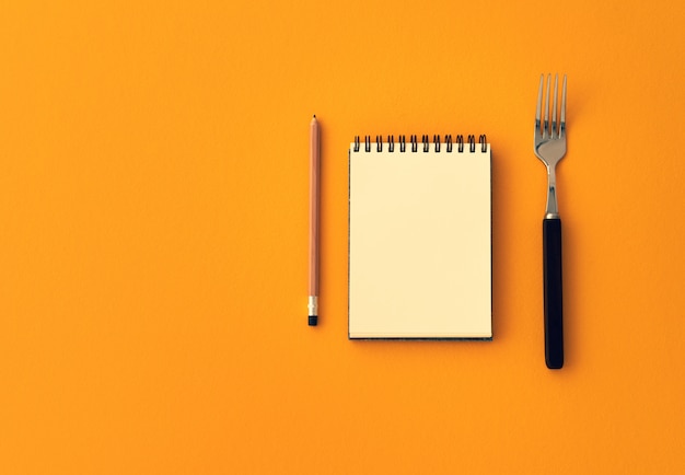 space notebook with pencil and fork